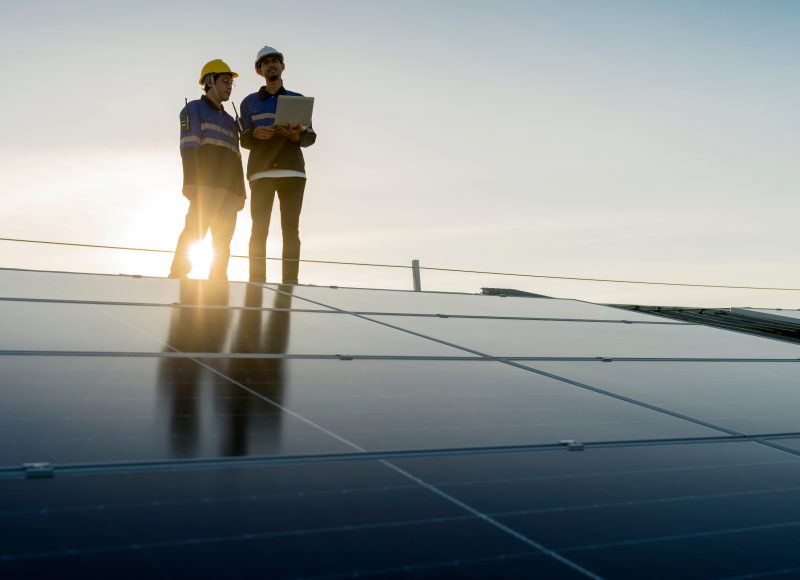 Two workers inspecting solar panels